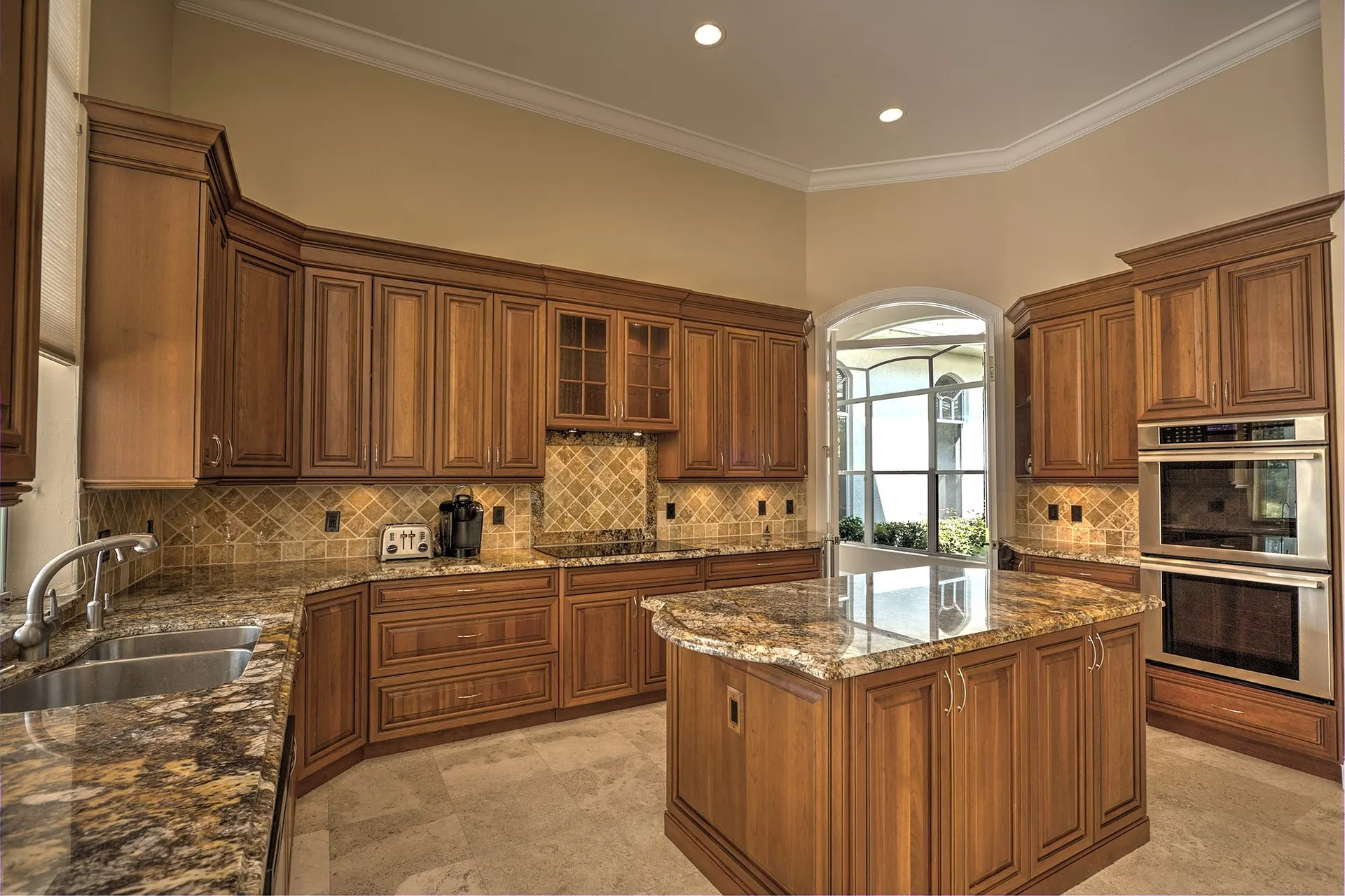 A remodeled kitchen with wood cabinets, granite counters and a center island