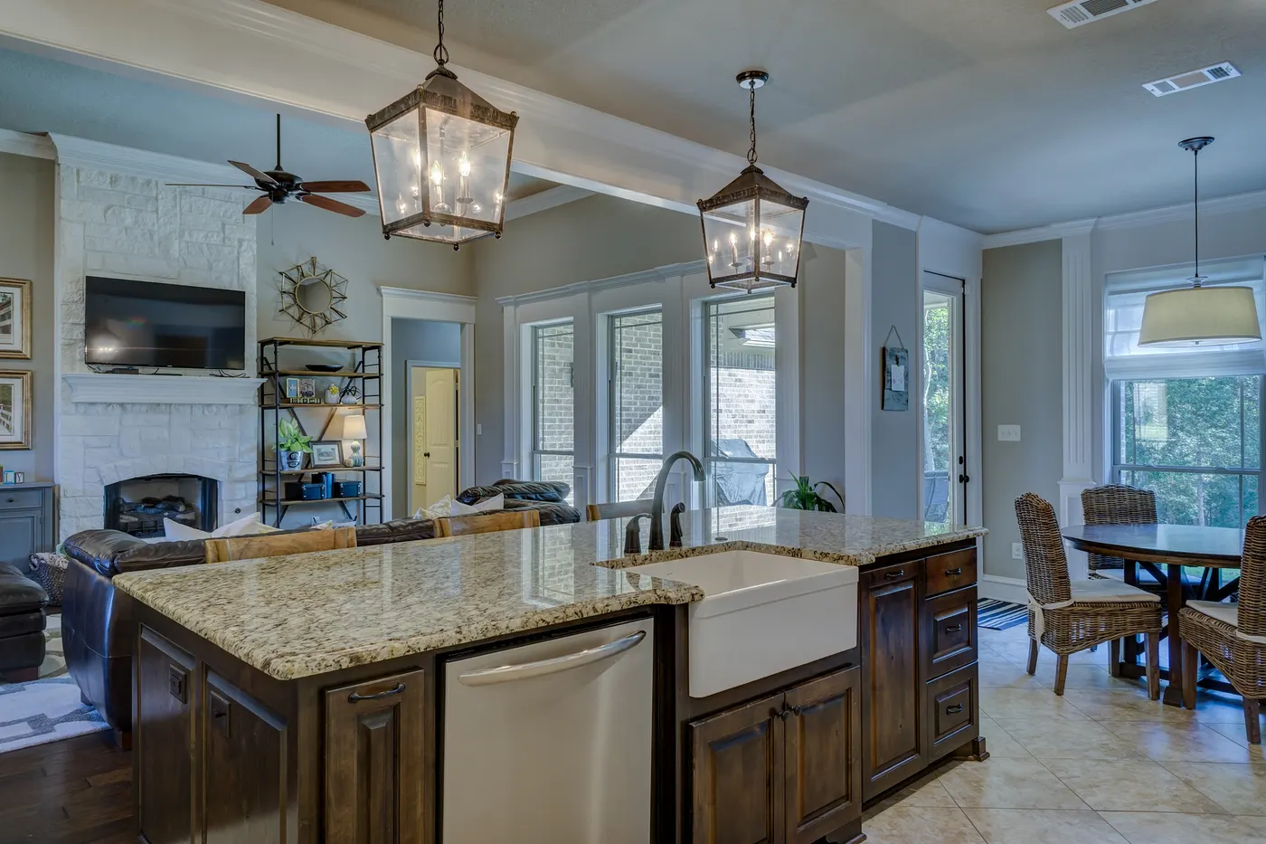 An open-plan kitchen and family room with a granite island and pendant lights