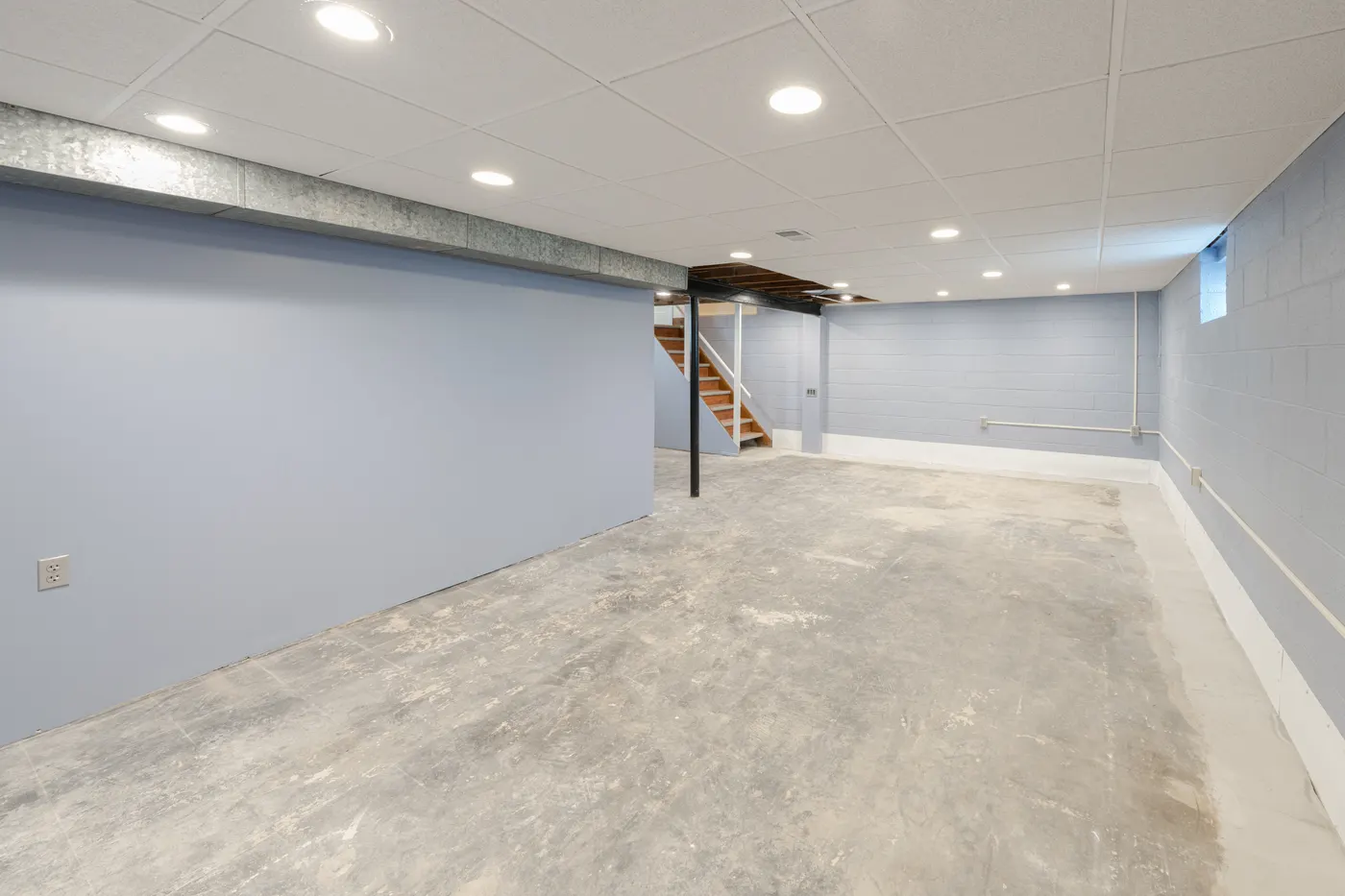 An open basement with painted walls ready to be finished