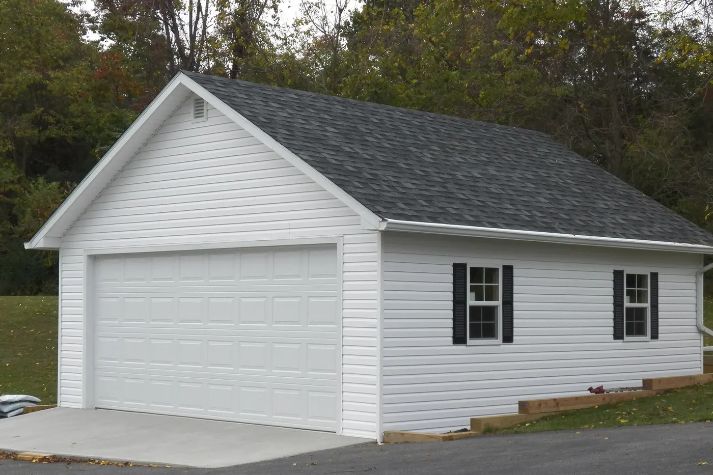 A detached garage with a white double garage door