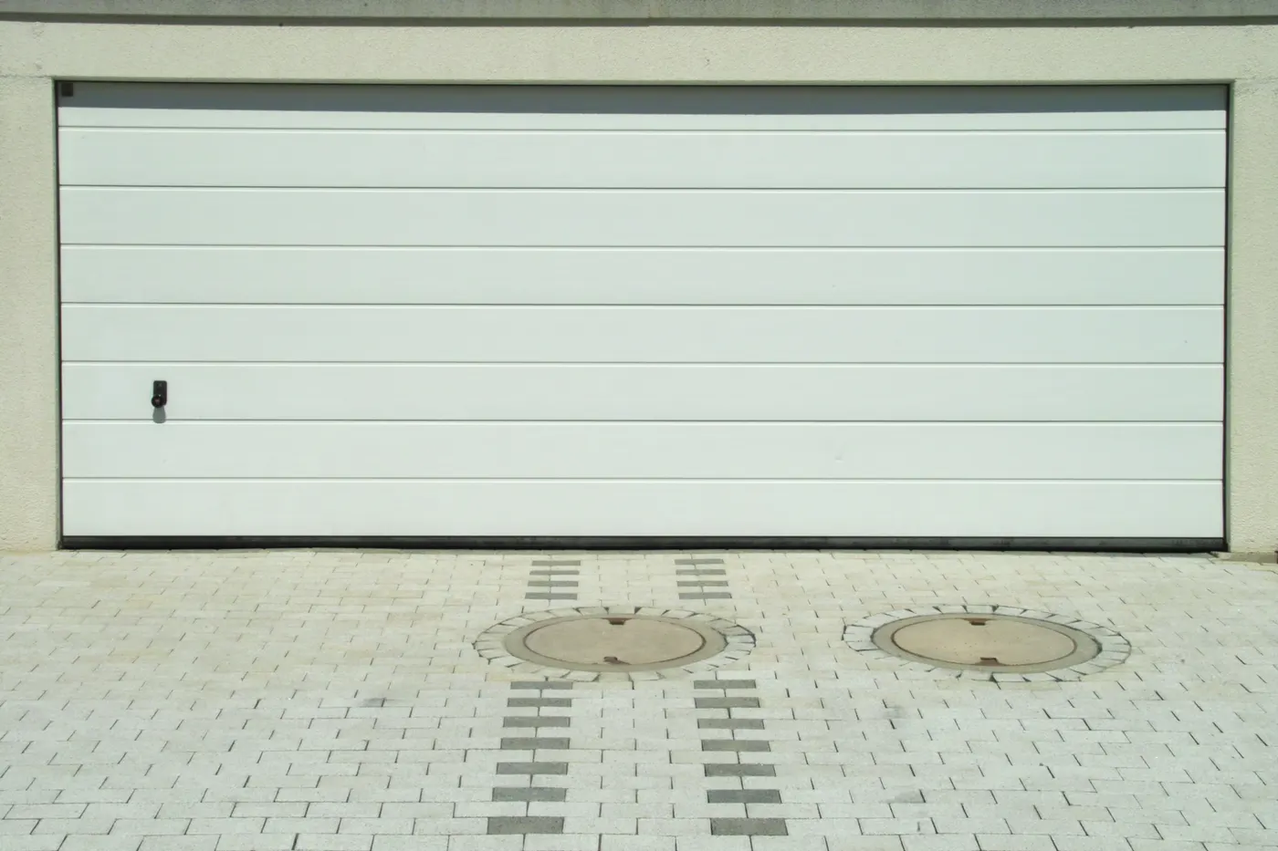 A white sectional garage door with smooth panels