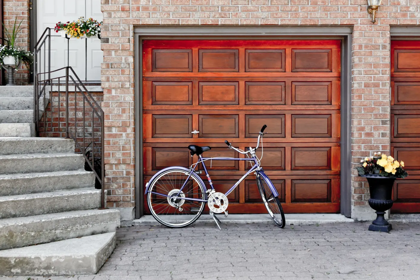 A wood-panel garage door beside the front steps of a home