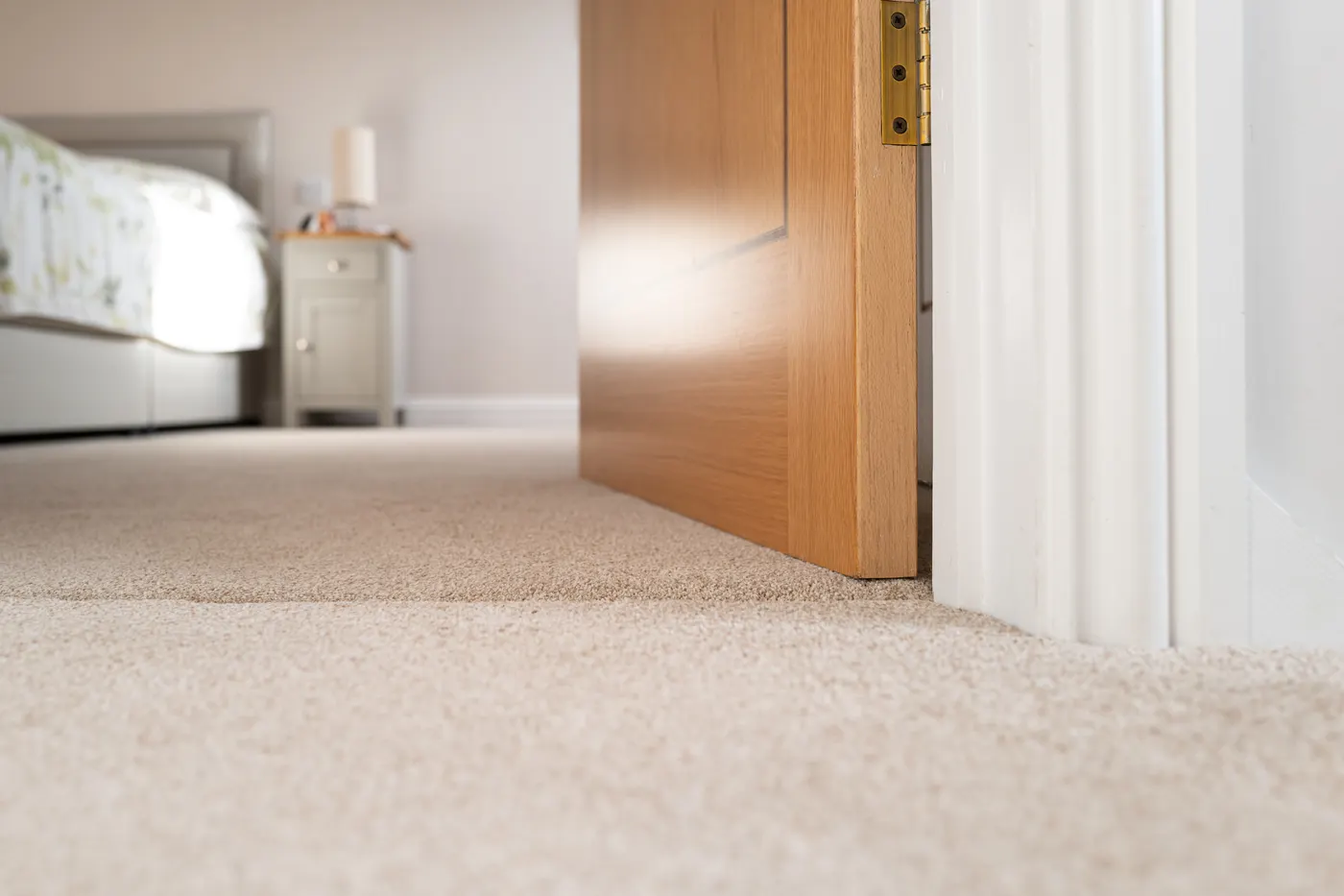 A newly carpeted bedroom with a wood door