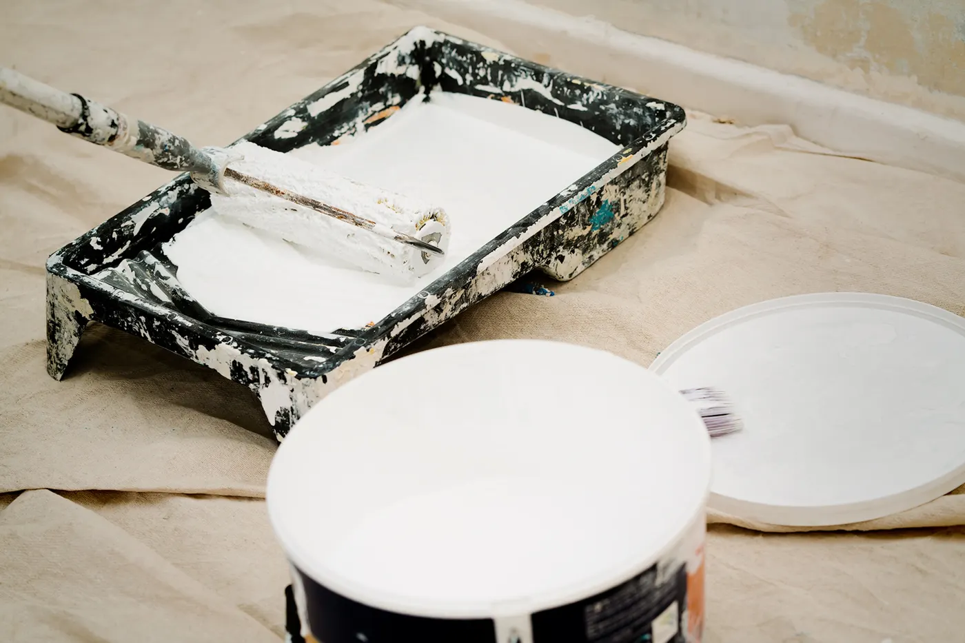 Paint trays and a can of white paint ready for use