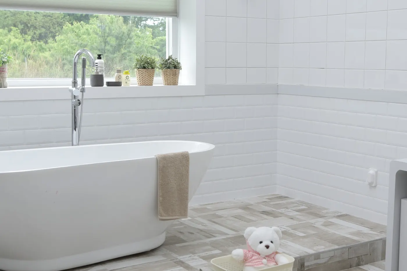 A bathroom with white subway tile walls and a tiled floor